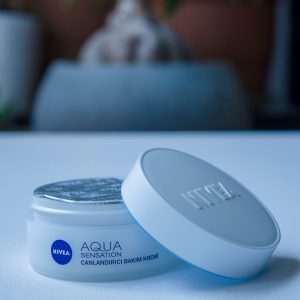 Close-up shot of Nivea Aqua Sensation skincare cream in a stylish container.